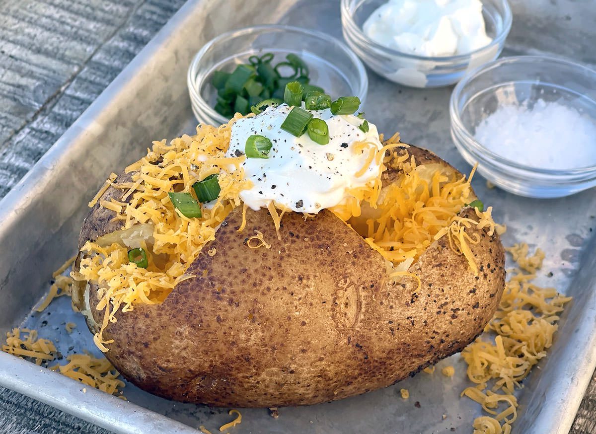 Smoked baked potato loaded with cheese and sour cream.